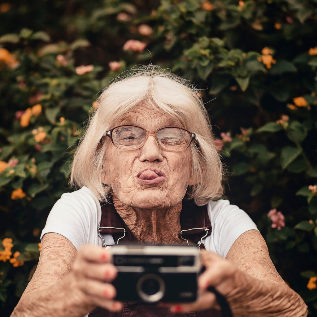 mamie jouant à prendre des photos avec une grimace de concentration et de jeu