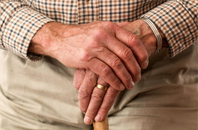 mains âgées posées sur une canne, ancrage de la sophrologie